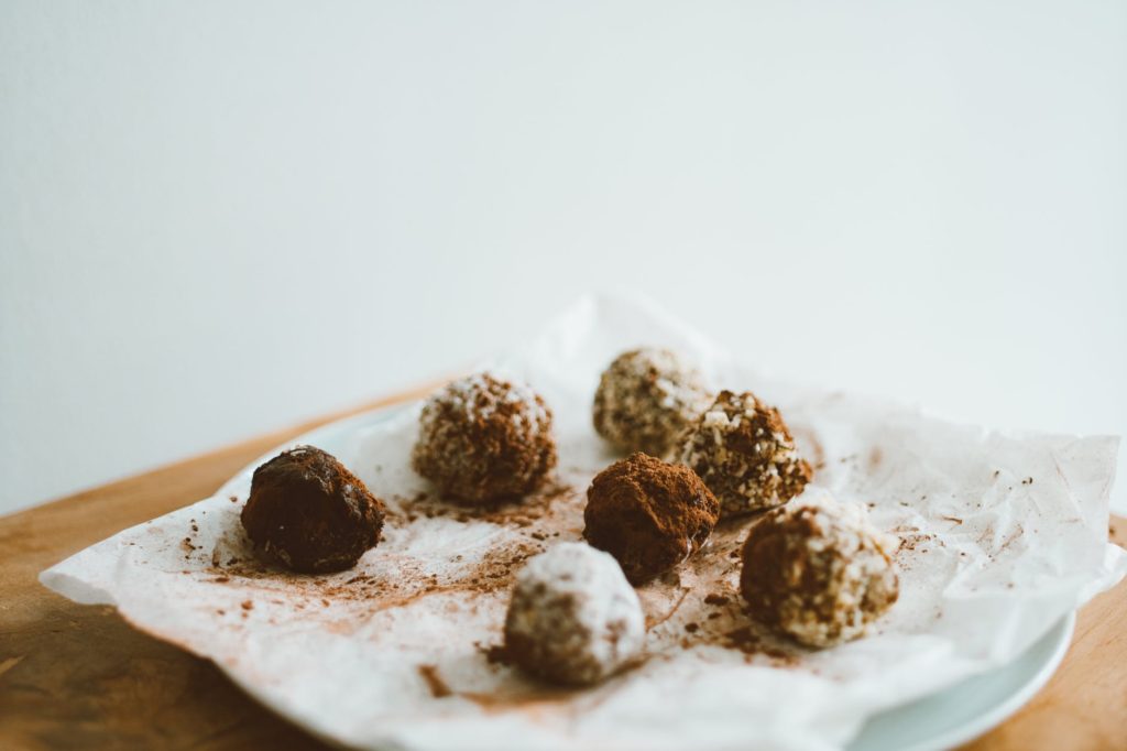 chocolate balls on baking paper on white ceramic plate